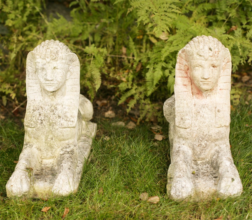A fine pair of recumbent composition stone sphinxes, each with traditional Pharaonic headdress.