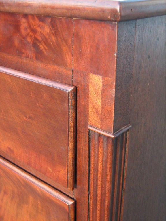 Mahogany chest with brass hardware, decorative inlaid on front panel with fluded sides.