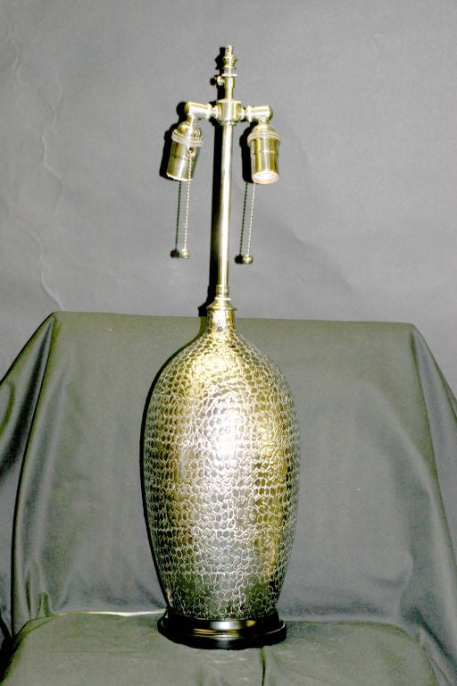 Pair of silver textured vessels with lamp application. The newly wired lamps come with dual, individually controlled sockets and can accommodate up to 100 watts each. The vases are 14