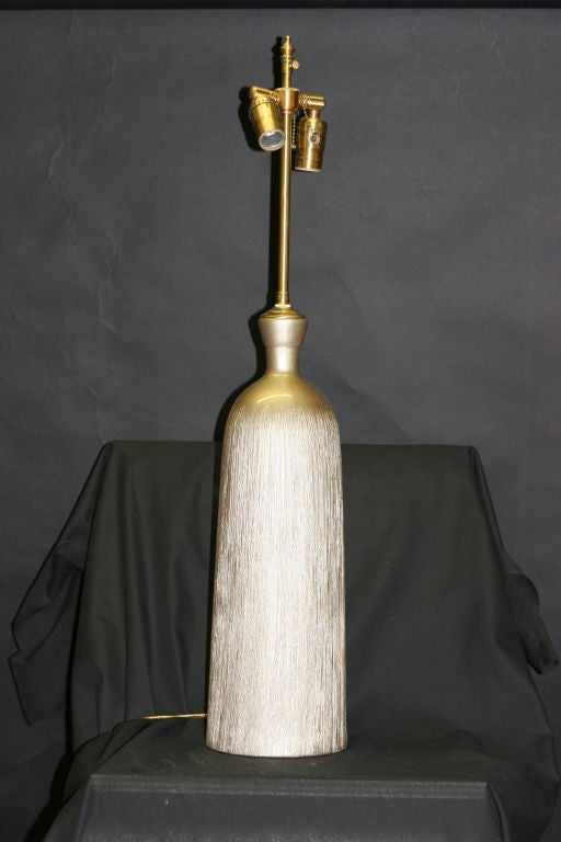 A set of  Champagne Textured Ceramic vessels with lamp application.  The hardware is brushed Brass bearing dual sockets with individual controls.  The shade post extends an additional 3