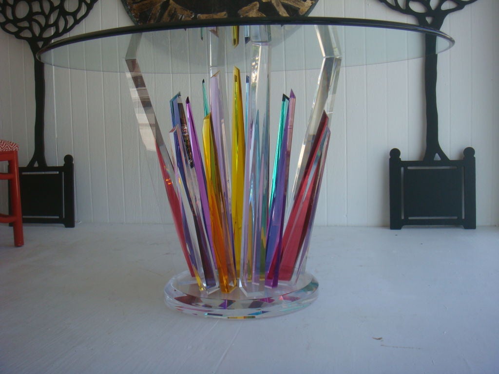 A Lucite Table of multiple colored stalagmites suporting a glass top.A most unusual and beautiful table. Each ray moves from clear in color to a vibrant color; giving the feeling of having many rays of different heights. This is a work of art.