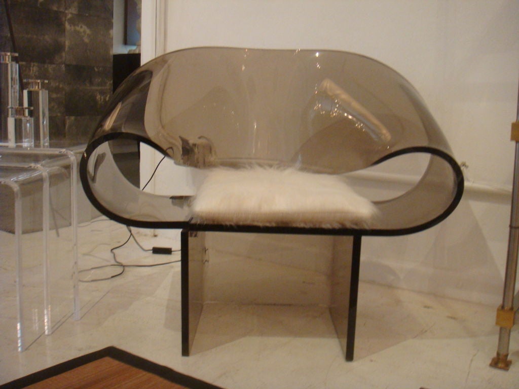 A lucite chair sculpted in the form of a ribbon. Chair is of a smoked colored lucite. The sculptural form is organic in feeling and a perfect accent piece. Chair has great form and very comfortable.