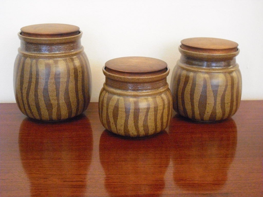 A great set of three studio pottery stoneware jars with walnut lids by noted master potter, Victoria Littlejohn. The jars have wonderful cat striping decoration. The are in mint condition. Signed. They measure 8.5