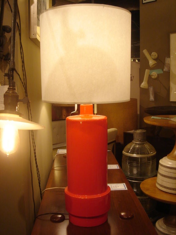 Vintage table lamp in orange glazed ceramic featuring a stepped design.  USA, circa 1970.<br />
<br />
Dimensions of Lamp:<br />
32.5 inch height with shade<br />
22 inch lamp height (without shade) up to metal socket holder<br />
19.5 inch