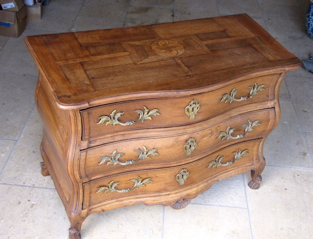 A SUBLIME FRENCH ROCOCO WALNUT BOMBE-FORM THREE DRAWER COMMODE