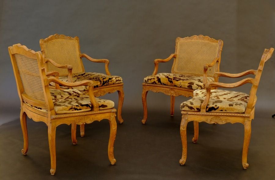 SET OF FOUR FRENCH REGENCE CARVED BEECHWOOD CANED OPEN ARMCHAIRS