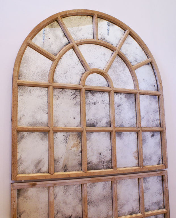 An antique stripped pine arched window frame in two parts with later inset 