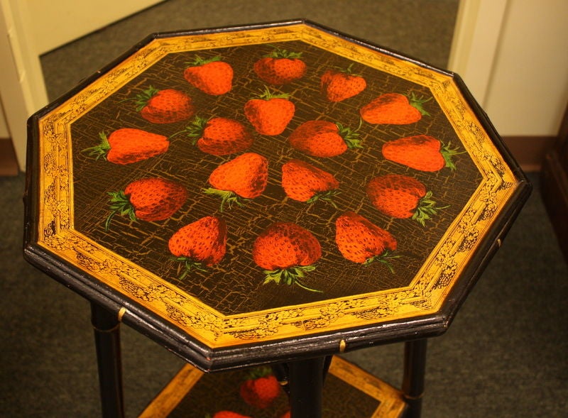 A small antique English side table, newly decoupaged with whimsical strawberries. The bamboo, which has been painted black with gilt accents, is in good, sturdy condition. Charming and useful as an end table or lamp table.
 