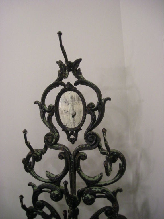 Antique distress painted cast iron hat rack fitted at the<br />
base with a shell design; a shallow receptacle holds canes and umbrellas; overall assembly held together with several screws.