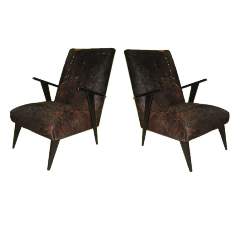 Elegant pair of Italian Mid-Century Modern Armchairs / club chairs attributed to Ico Parisi with a stunning angular profile including arms and rear saber legs, the pieces are covered in leather cowhide.