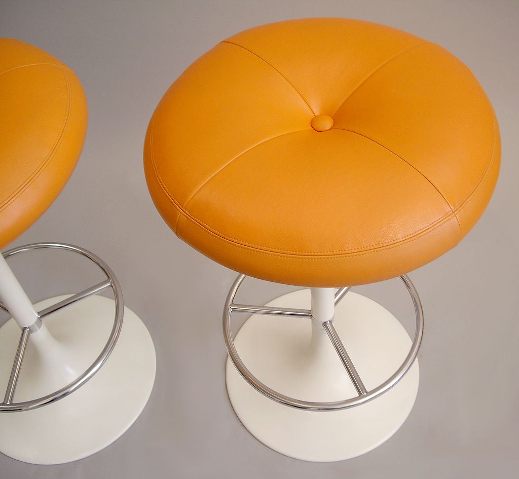 Pair of white and polished metal barstools. Orange upholstry.  <br />
Original label reads: AB Broderna Johanson Fatoljindustri Markaryd.<br />
Made in Sweden. Price is for the pair