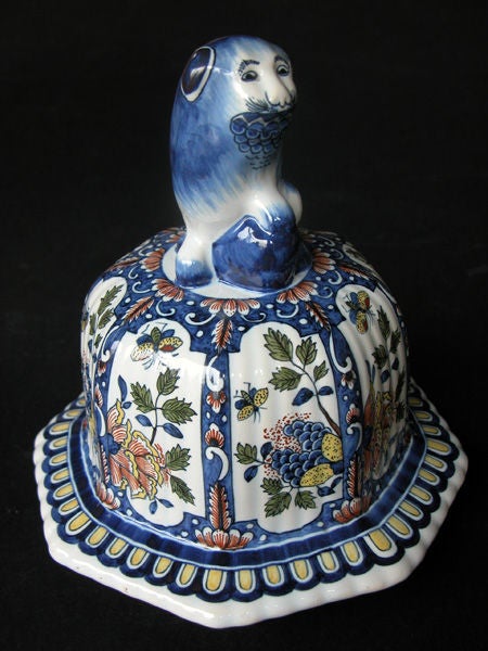 A massive Belgian polychromed lobed octagonal ginger jar with lid surmounted by a regal lion; by Boch Freres Keramis, La Louviere, Belgium; the domed lid topped by a fu lion; resting on a lobed tapering urn adorned with 8 reserves with exotic birds,