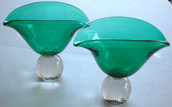 A shimmering pair of American mid-century emerald green art glass vases with clear spheroid bases 