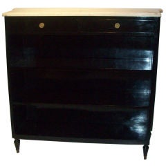 An ebonized marble-top open bookcase in the Jansen Manner