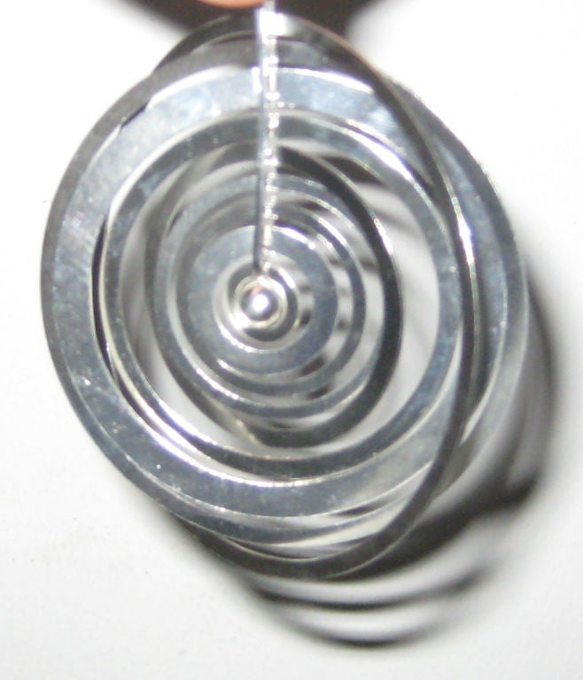 “Silver Moon” (Hopeakuu) sterling silver pendant comprising nine kinetic concentric rings of differing widths secured through a vertical rod, designed by Tapio Wirkkala in 1970 and produced by N. Westerback.