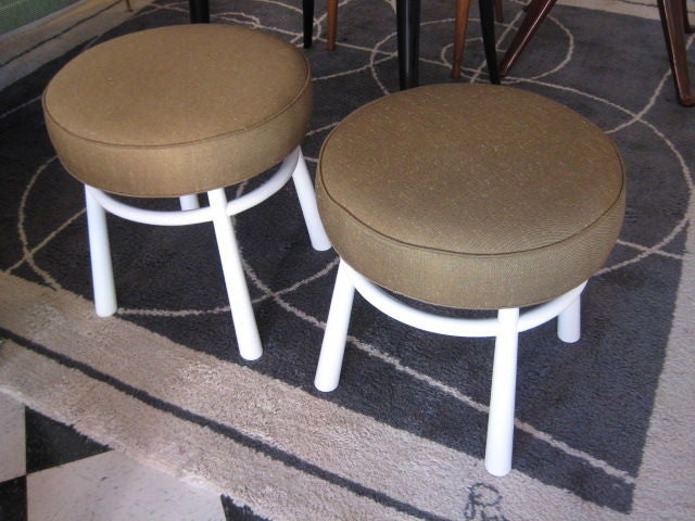 A pair of uphosltered stools by T.H.Robsjohn-Gibbings for Widdicomb, redone in white laquer, reupholstered in beige linen fabric.