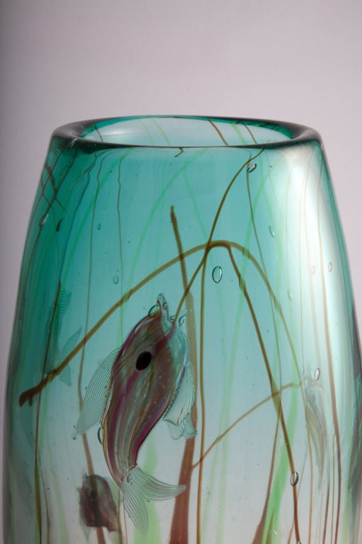 A colorful art glass vase in an oval form with multi-color tropical fish swimming in a sea of aqua blue within coral and green colored plants. By Barbini. Italy, circa 1960.