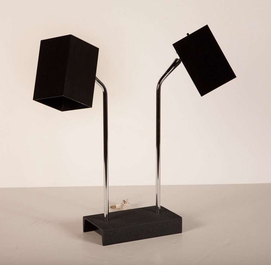 A black and chrome desk lamp with two adjustable lights each on separate arms that are mounted on a black metal base, by Kovacs. American, circa 1970.