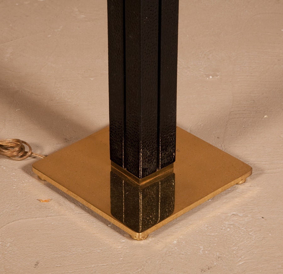 An ostrich-wrapped floor lamp in a channeled, square column-form with polished brass square base and fittings and two lights by Karl Springer. U.S.A., circa 1970.