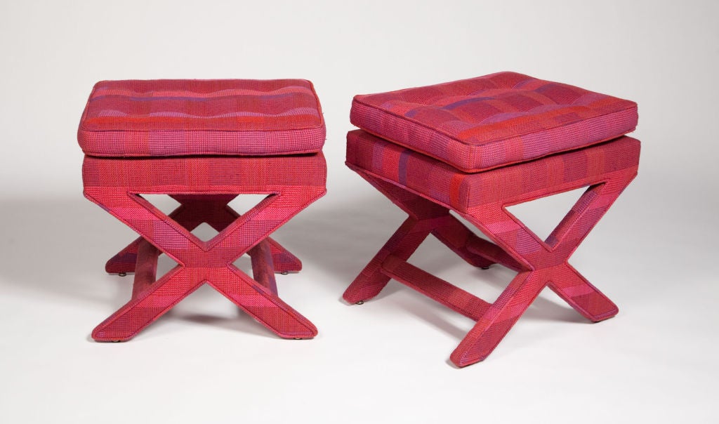 A pair of benches with fully upholstered x-frame bases. The upholstery is original Jack Lenor Larsen woven fabric in a sumptuous fuchsia and violet plaid pattern. Manner of Billy Baldwin. U.S.A., circa 1950. [DUF0132]