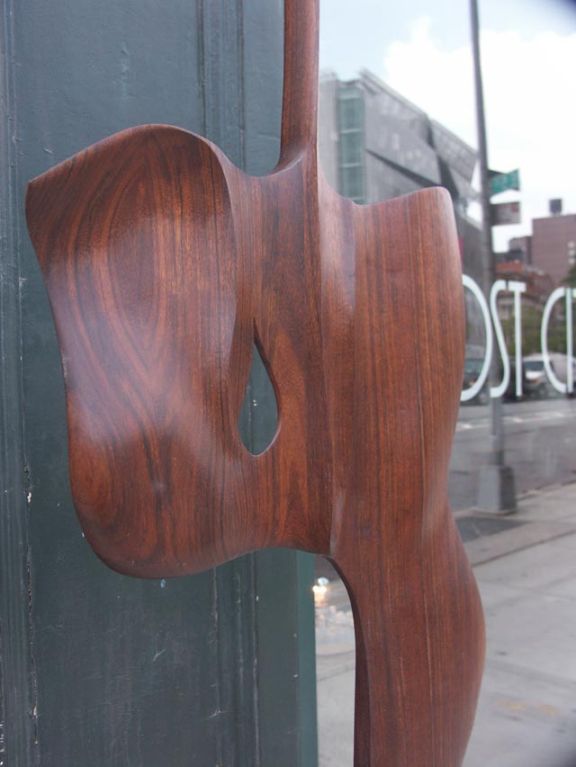 Expertly carved and sculpted work by Frank Flynn. Sensuously worked black walnut panel has been worked and reshaped with a smooth surface akin to sand dunes. The form broadens greatly with a teardrop hole carving, and an extremely slender 