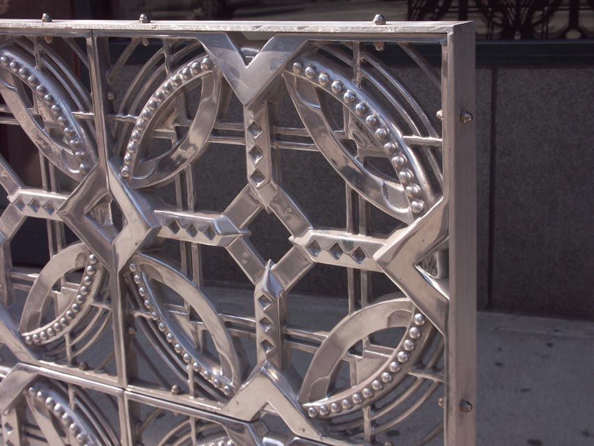 Lovely firescreen, room divider, window sculpture, composed of 4 recast from original, machine age grilles, mounted in a steel frame. Each panel showcases an abstract depiction of the mechanistic motifs popular in the 1920-30's, cast in aluminum and