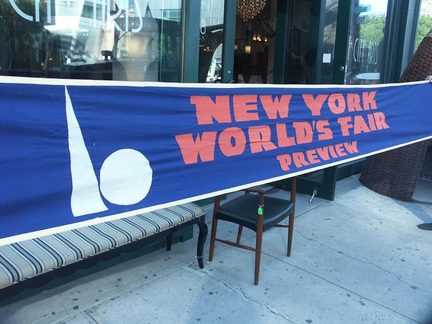 This huge banner was strung across Fifth avenue in Manhattan, as advertising prior to the opening of the 1939 New York World's Fair. Over 12' in length, the cotton banner is dyed a deep blue, with lettering in a bold orange tone, with the famous