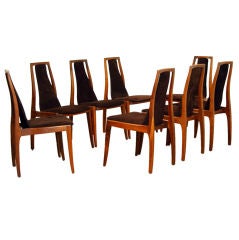 Eight walnut and brown suede dining chairs by John Kapel