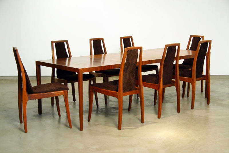 Eight walnut and brown suede dining chairs by John Kapel