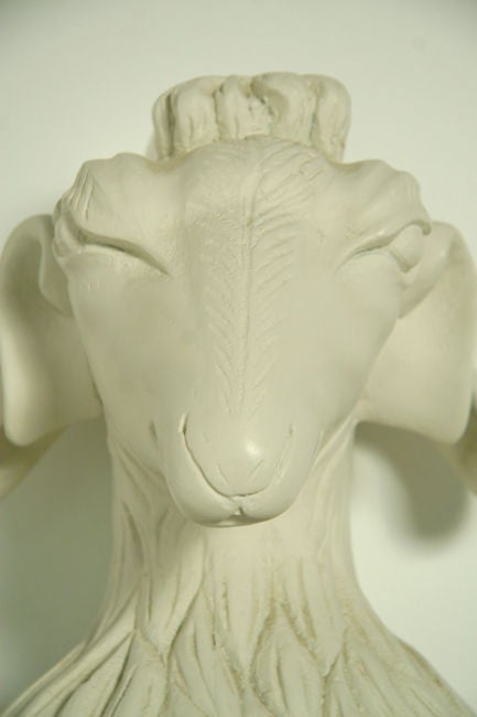 Pair of carved white plaster rams heads