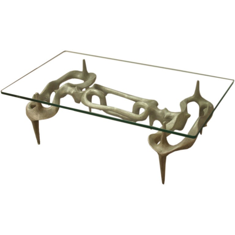 Sculptural glass top coffee table with cast aluminum base. The coffee table was designed and fabricated by French artist and sculptor Victor Roman (1937-1995).