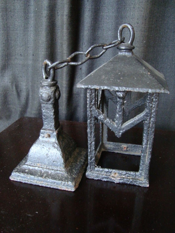 A Classic Mission style lantern in hand-forged metal with an arrow design on a hand-forged chain and matching canopy.