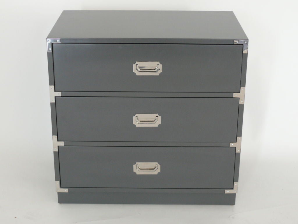 Handsome pair of campaign dressers completely refinished with dark grey lacquer and polished nickel hardware.