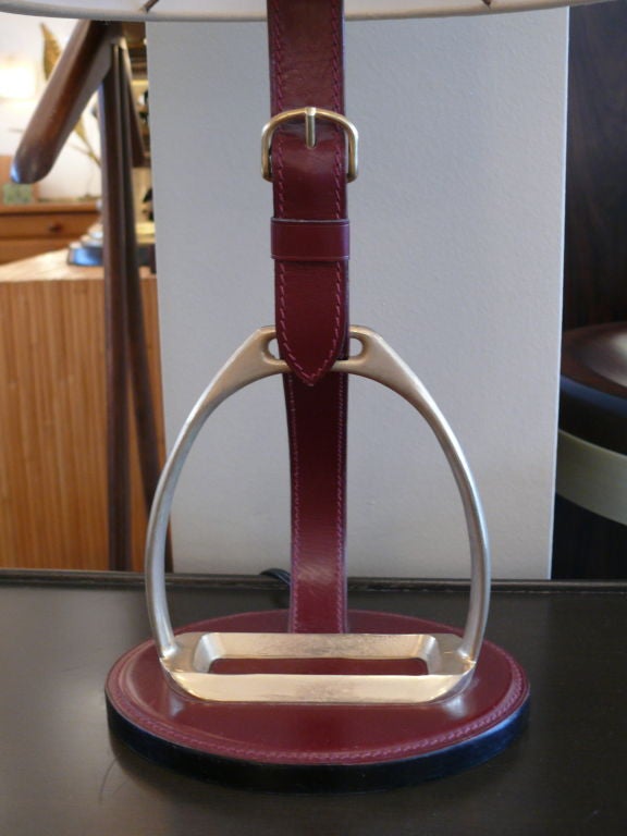 Red leather table lamp attributed to Hermes with brass horseshoe, great curved shape and new silk shade.