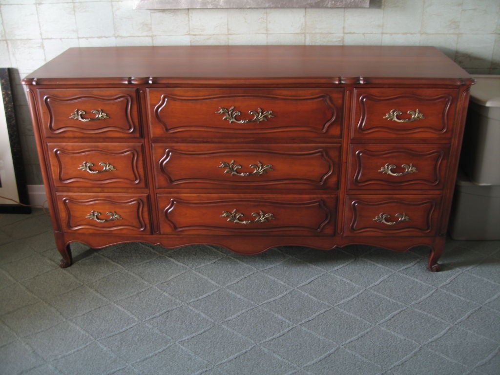 Superb Louis XV style triple dresser dating to the 1930's. Rendered in solid cherry with oak drawer interiors, this piece is so fantastically made, with rich hued cherry planks routed on the drawer fronts, cabriole legs and whorl feet. Paneled