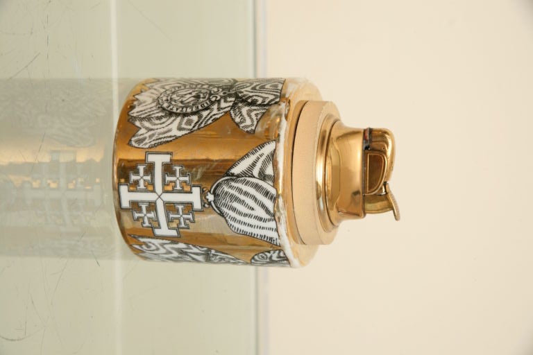 Delightful 3 piece Fornasetti smoking set consisting of lighter, ashtray, and cigarette holder. All fashioned of porcelain ceramic with gold background and four pattern repeat design. Lighter can be made to work or new inserts are available. Stamped