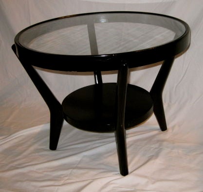 Black glossy side table base with a glass top.