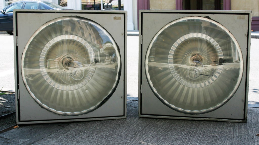 Wonderful pair of one-of-a-kind industrial lights    The lights were originally stadium light and still retain their enormous industrial bulbs  Encased in metal There is an opening in the bottom for wiring and a hinged door with original convex glass