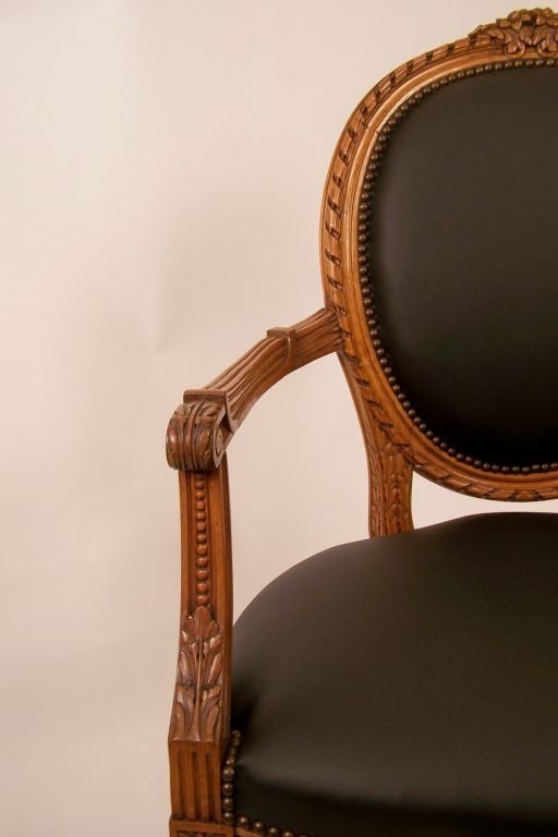 Carved Louis XVI Style French Walnut Armchair with Black Leather Upholstery For Sale