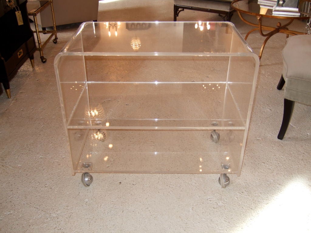 Clean lucite creates a sleek side table or movable shelf.  Three roomy shelves for all your storage or display needs.  Rests on four casters, making it easy to move or store.