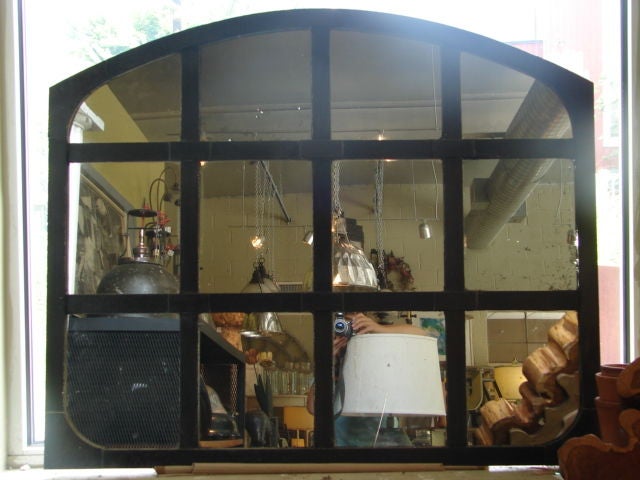 Cast iron arched window frame with new mirrored glass, pair available.