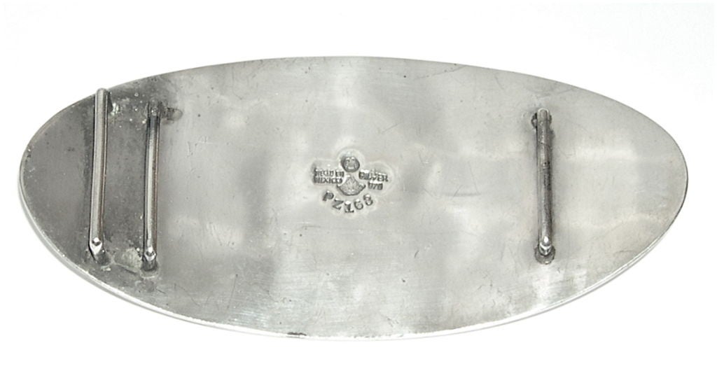 This large impressive belt buckle was designed by the master silversmith, Antonio Pineda. It was handmade in two heavy pieces of silver, one with cut out figures and the back one with the silver darkened to show off the figures. The buckle is
