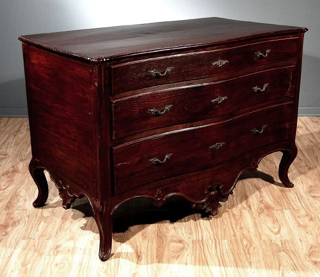 Portugese Regence  Sang de Boeuf Three Drawer Commode in Chestnut with Short Cabriole Legs and Undulating Apron with Rocaille Decoration. Circa Mid 18th Century