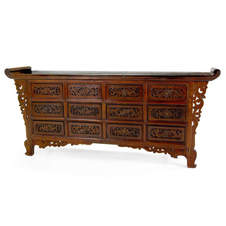 A 19th century Northern Chinese elmwood altar coffer with everted ends and highly carved drawers depicting flowering lotus and scrolling vines.<br />
<br />
Pagoda Red Collection #:  U006<br />
<br />
<br />
Keywords:  Sideboard, buffet,