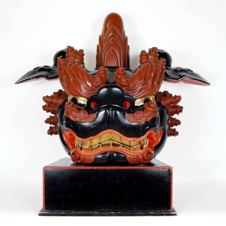 A fantastic male and female pair of Japanese red and black lacquered lion masks used in traditional shishimai (Lion Dances) with highly carved brows and manes and gilt eyes and teeth.  Male mask is topped with a phallus shaped finial, and the female