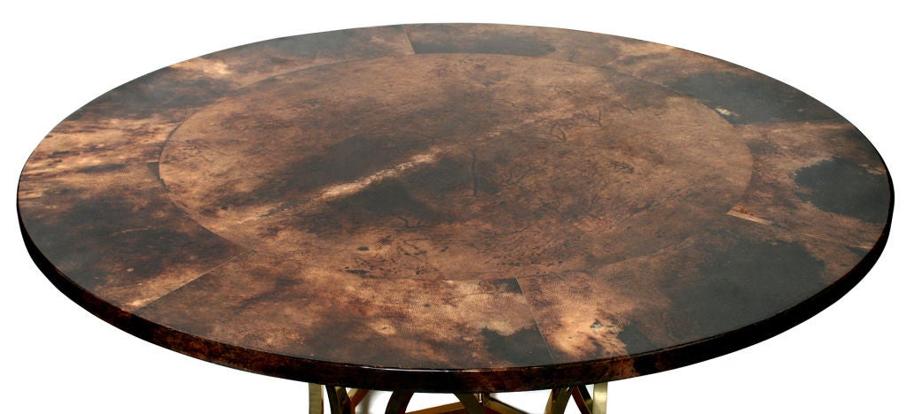 This is  an interesting table.  The lacquered parchment top sits atop a brass and wood base.