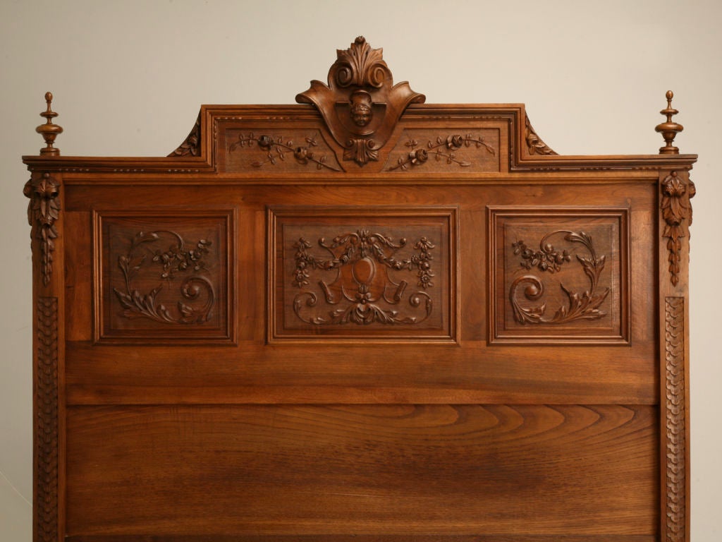 Opulent over the top French walnut bed with numerous hand-carved details including cherubs, putti, and fantastic foliate swags and scrolls. WOW! Believe it or not, this remarkable bed, even has fluted, floral decorated matching siderails showing its