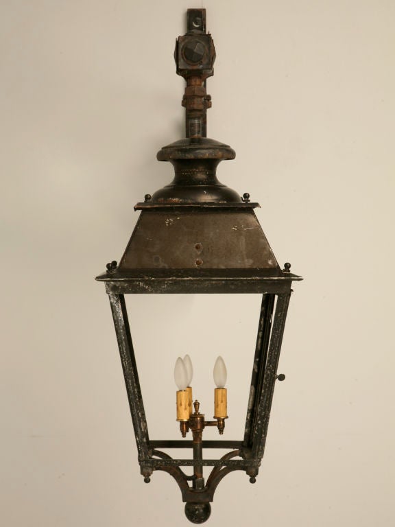 Substantial vintage French iron lantern on a scrolled iron bracket. Absolutely marvelous, we located this outstanding lantern adorning a building on the outskirts of Toulouse, in the South of France. Upon arrival here in the USA, we completely