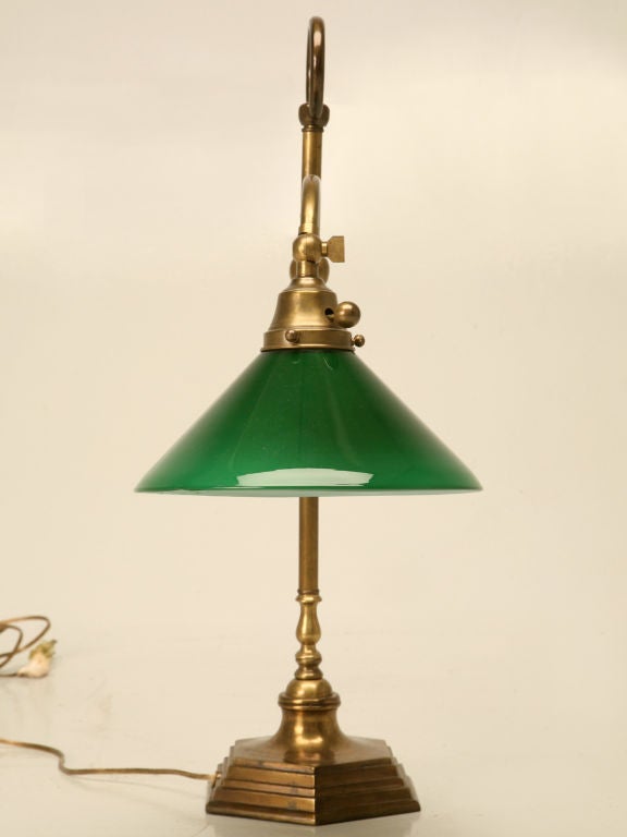 High quality vintage American brass lamp perfect utilized on a desk, end table, or nightstand. Heavy weighted base assures stability, while a swivel head directs light exactly where you need it most. The green cased glass shade gives this beautiful