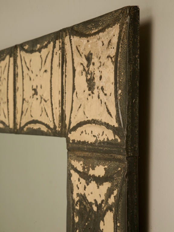 Newly made mirror utilizing antique American tin ceiling tiles as a frame. Add instant charm and character to any space by adding this unique and charming mirror. With its embossed tin plates and weathering paint, it adds style and sophistication